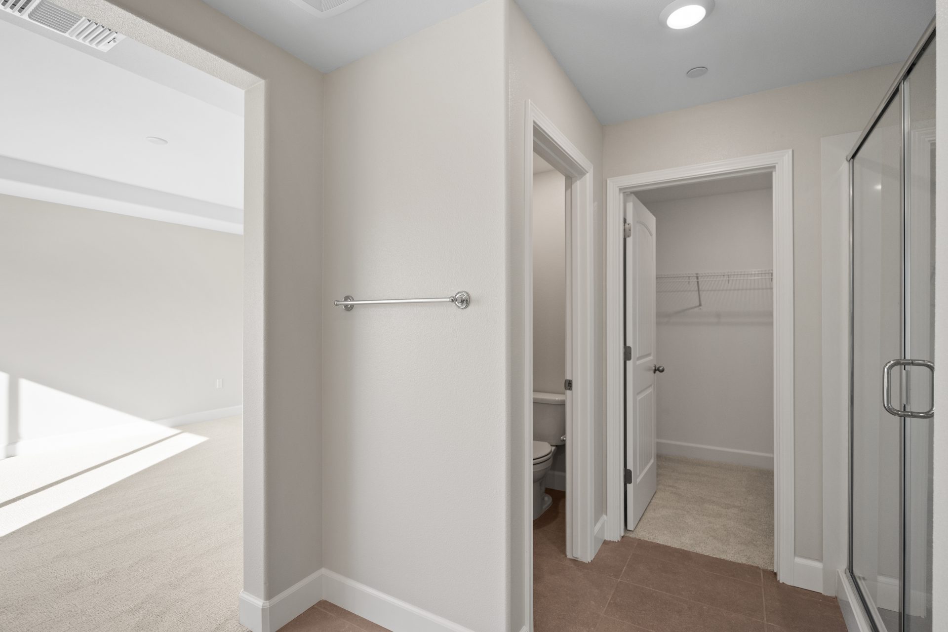 View from the bathroom with bedroom on the left, to the right a closet, enclosed toilet and shower.