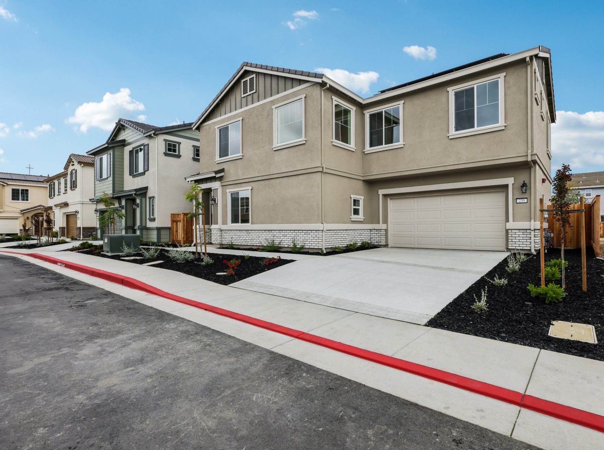 The exteriors of three- two story homes with selective paint color schemes, dark mulch and green landscaping.