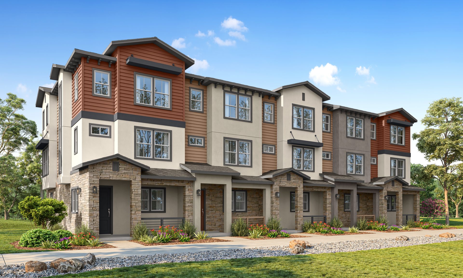 Modern row of three-story townhouses with mixed siding and stone accents, featuring large windows, small front porches, and landscaped greenery under a blue sky