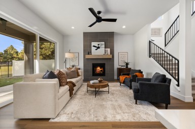 Modern furnished living room with white walls and large windows
