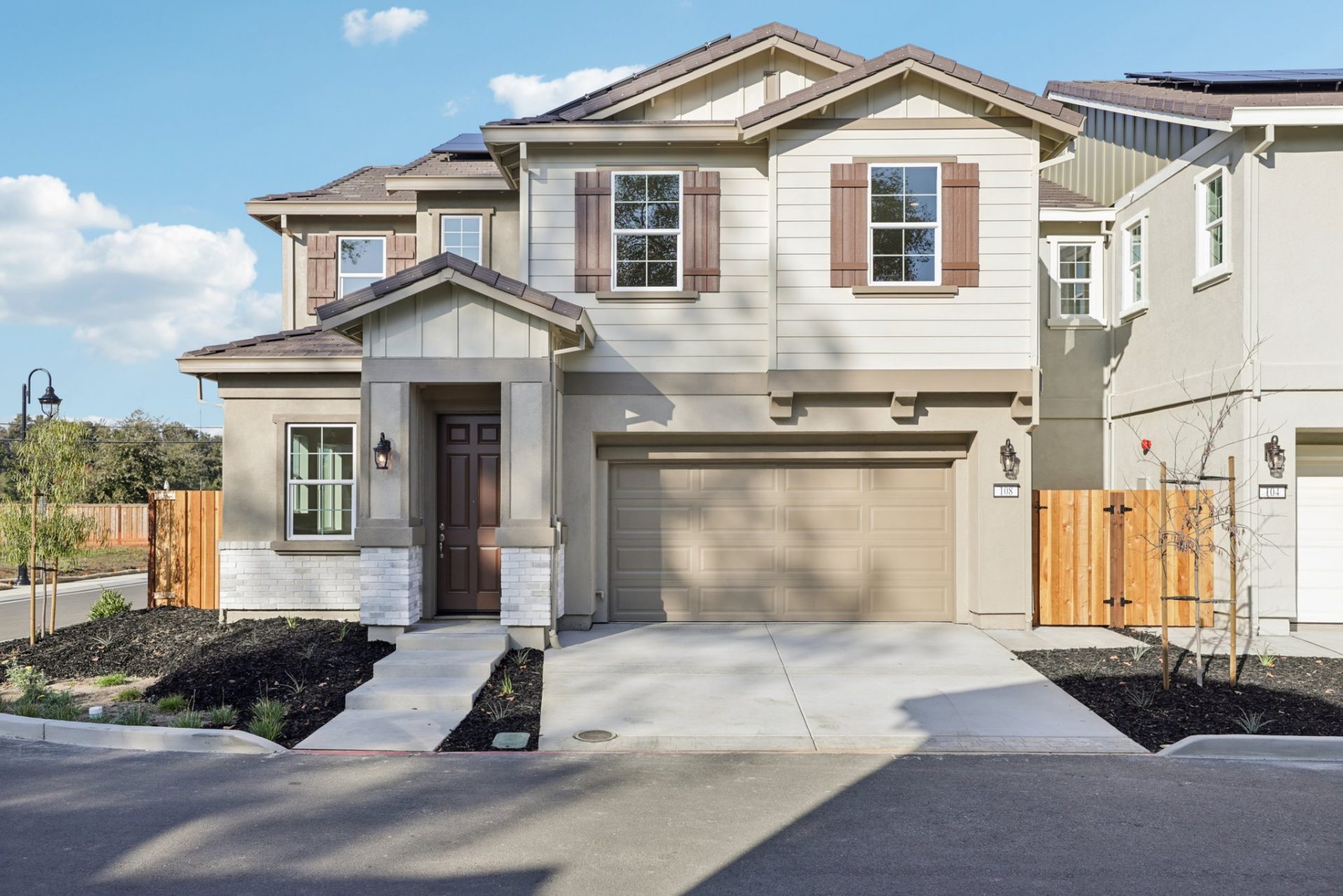 Exterior photo of a two story single family home with a 3 color paint scheme, two car garage, horizontal siding and shutters.